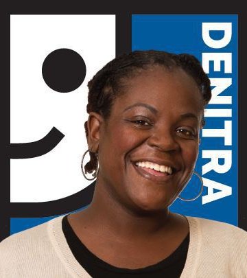 Denitra smiling in front of Goodwill logo