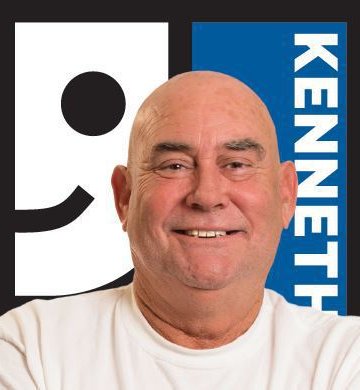 Kenneth smiling in front of Goodwill logo