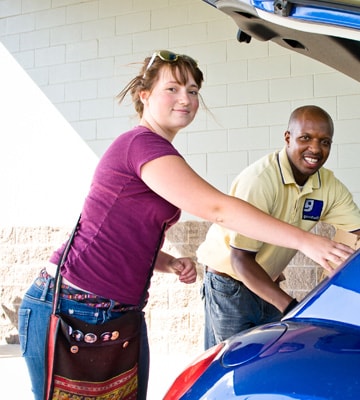 Woman dropping off donations at Goodwill as a goodwill volunteer assists her