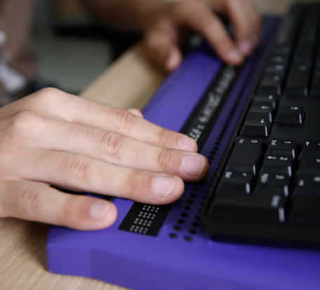 Hands using a braille keyboard