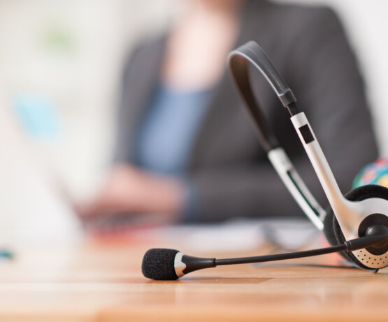 Headset device with woman on laptop in background