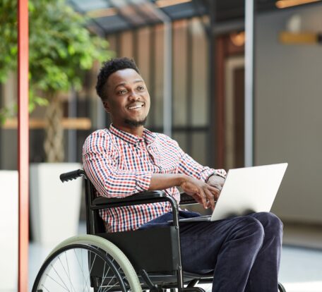 man in a wheelchair with a laptop