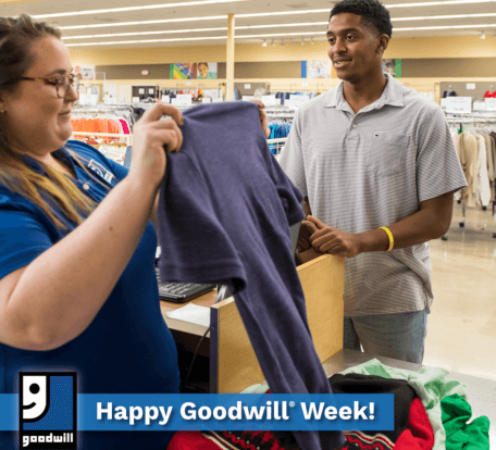 Cashier holds up purple shirt a man is buying