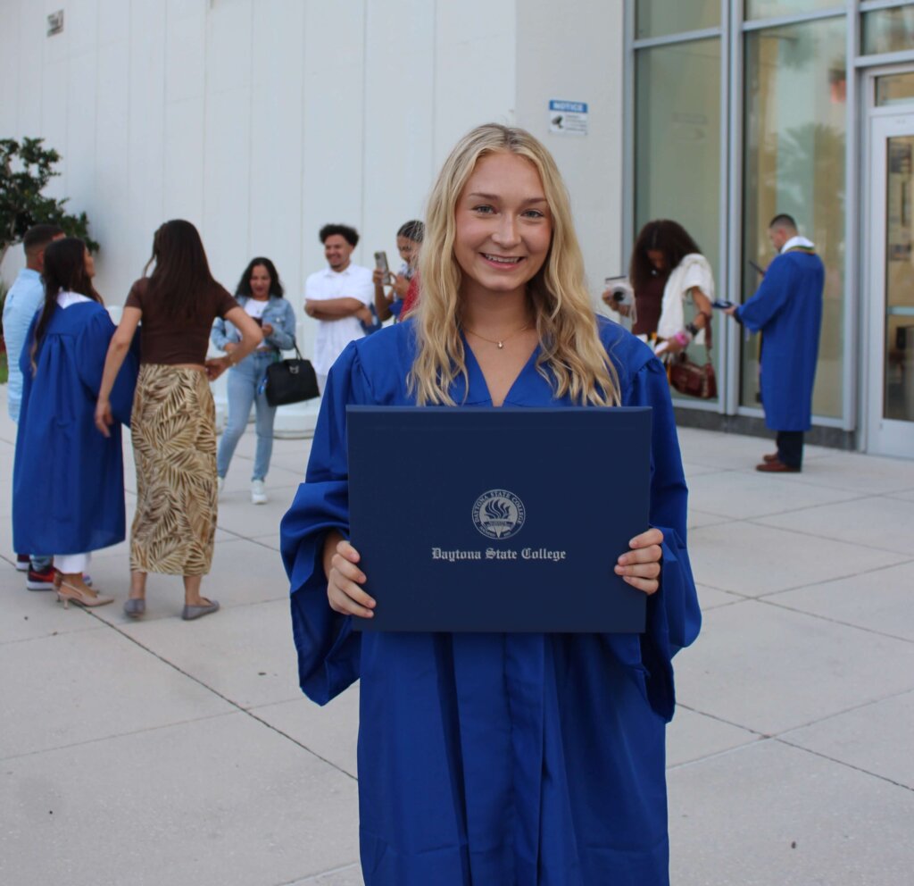 Taylor holds up her college degree